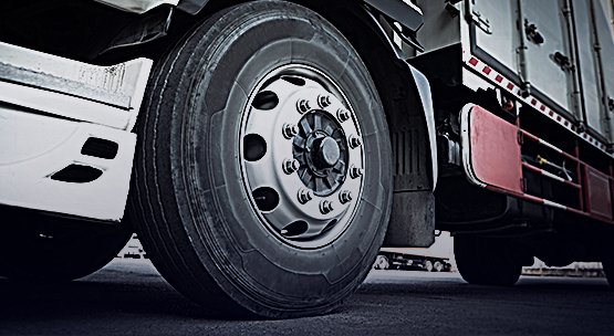 <p>Os pneus estão entre os principais custos operacionais para os transportadores rodoviários de cargas e passageiros. Devido às condições frequentemente precárias das rodovias, o desgaste dos pneus é acelerado. No entanto, existem métodos para prolongar a vida útil desses componentes.</p>

<p>Ao contrário dos pneus de veículos leves, os pneus de veículos pesados possuem uma banda de rodagem mais grossa. Além da recapagem, esses pneus podem ser ressulcados. A ressulcagem é um processo que remove borracha do fundo dos sulcos, estendendo a vida útil do pneu. Este serviço, no entanto, deve ser realizado apenas por empresas especializadas para garantir a segurança.</p>

<p>Normalmente, os pneus que podem passar pelo processo de ressulcagem possuem uma marcação específica na carcaça, identificada com a palavra "regroovable" (ressulcável) em ambas as laterais.</p>

<p>O processo de ressulcagem geralmente remove 4 milímetros de borracha do fundo dos sulcos, mas é essencial manter uma espessura mínima de 2 milímetros acima da cinta de proteção, que é a cinta metálica mais externa do pneu, além de preservar o TWI (Tread Wear Indicator).</p>

<p>A ressulcagem deve ser realizada quando os sulcos ainda possuem 3 milímetros de profundidade. Se a profundidade for menor, o equipamento de corte pode atingir a cinta metálica do pneu, inutilizando-o.</p>

<p>Cada pneu possui recomendações específicas para a ressulcagem, conforme descrito nos manuais técnicos do fabricante. Essas especificações variam de acordo com o modelo do pneu, influenciando as medidas da largura e da profundidade dos sulcos após o processo de ressulcagem.</p>
